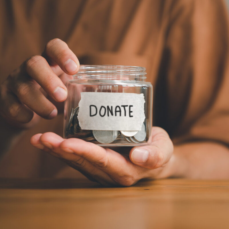 Man holding money jar with DONATE word written text label