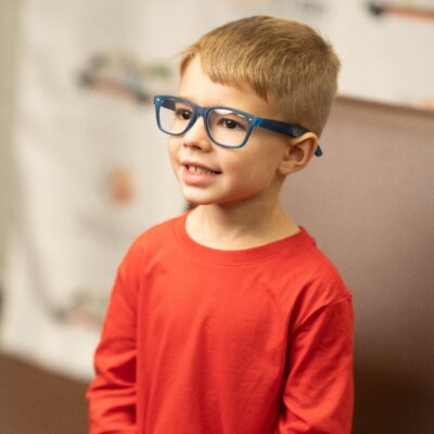 Young boy with glasses on his face at mobile vision clinic