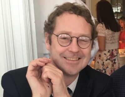 Stephen McKean is pictured smiling and in a black suit.